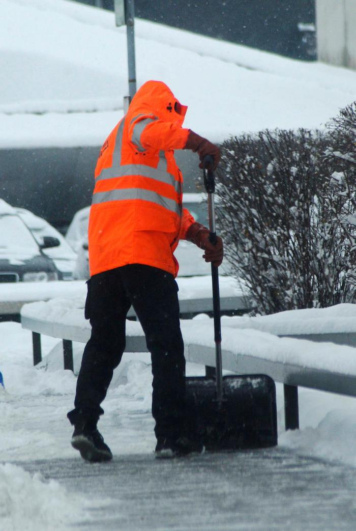 Professional UK contractor clearing snow outside a building